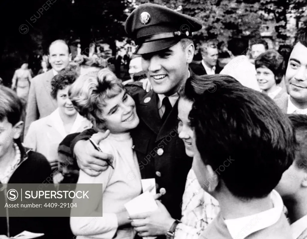 The American singer Elvis Presley with his fans in a park of Germany during his military service at Ray Barracks in 1958.