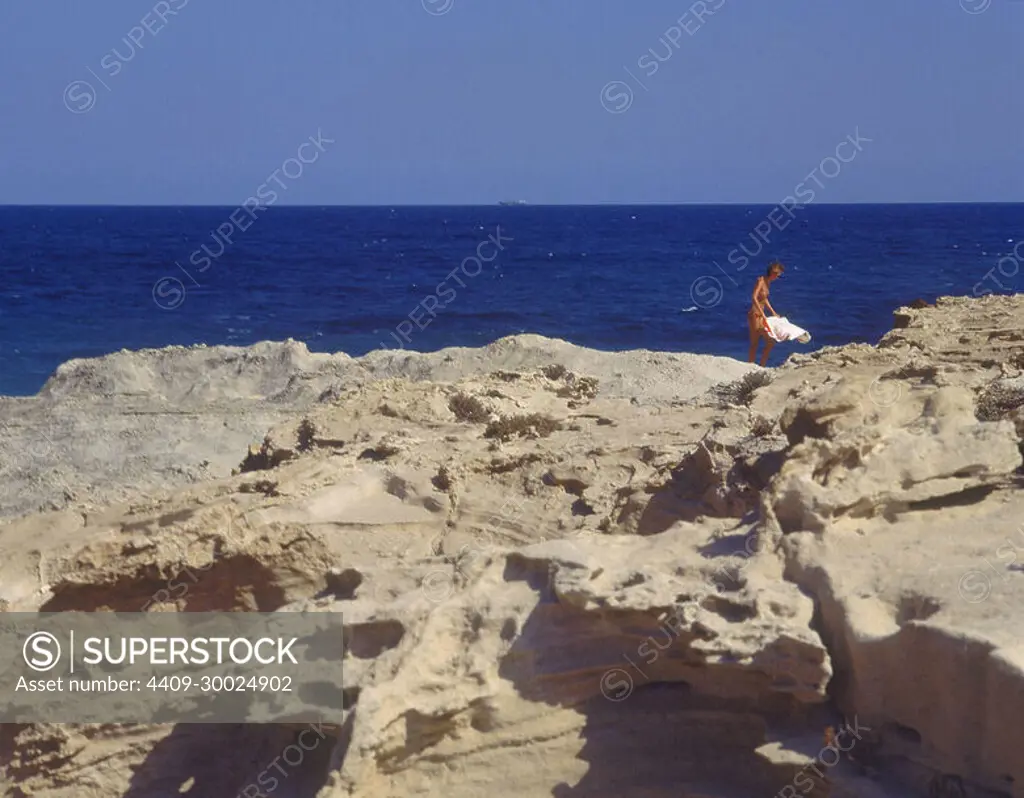 ZONA EROSIONADA POR EL MAR CON CHICA EN TOPLESS. Location: EXTERIOR. LOS  ESCULLOS. Almería. SPAIN. - SuperStock