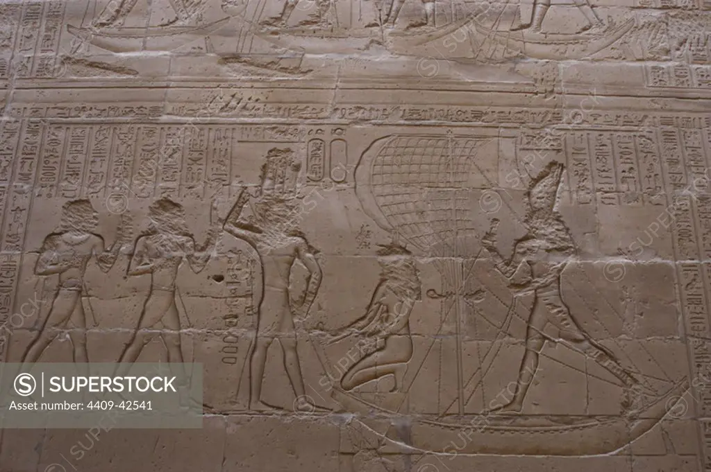 Egypt. Edfu. Temple of Horus. 3rd century B.C. Relief depicting the god Horus standing on a boat and avenging his fatherÕs murder in a battle with his Uncle, the god Seth, depicted in the form of an hippopotamus underneath. Horus, standing, and Isis, kneeing, in a ship with a sail capturing the Hippo.