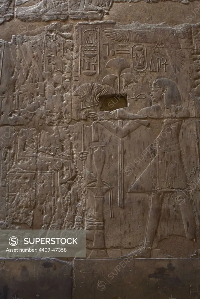 Pharaoh Amenhotep III offering to the god Amun lotus flowers and papyrus. New Kingdom. Temple of Luxor. Egypt.