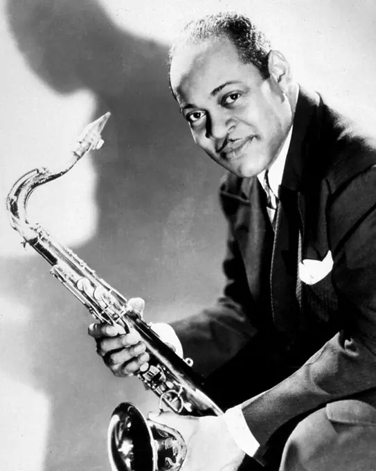 Studio portrait of American jazz saxophonist Coleman Hawkins holding his instrumental, 1940s.