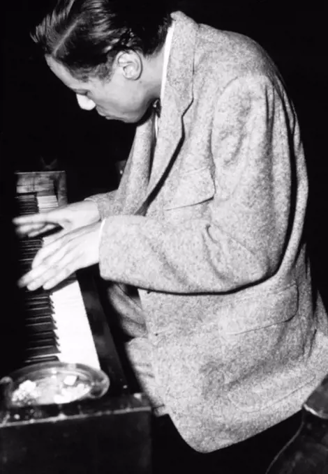 Jazz musician Horace Silver looking down at the keyboard while playing a piano, 1955.