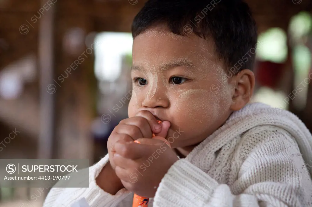 Child trying to inflate a balloon Burma