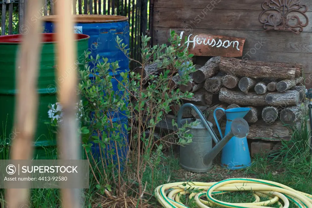 ""Attention Hérisson"" in front of a stack of wood in a garden