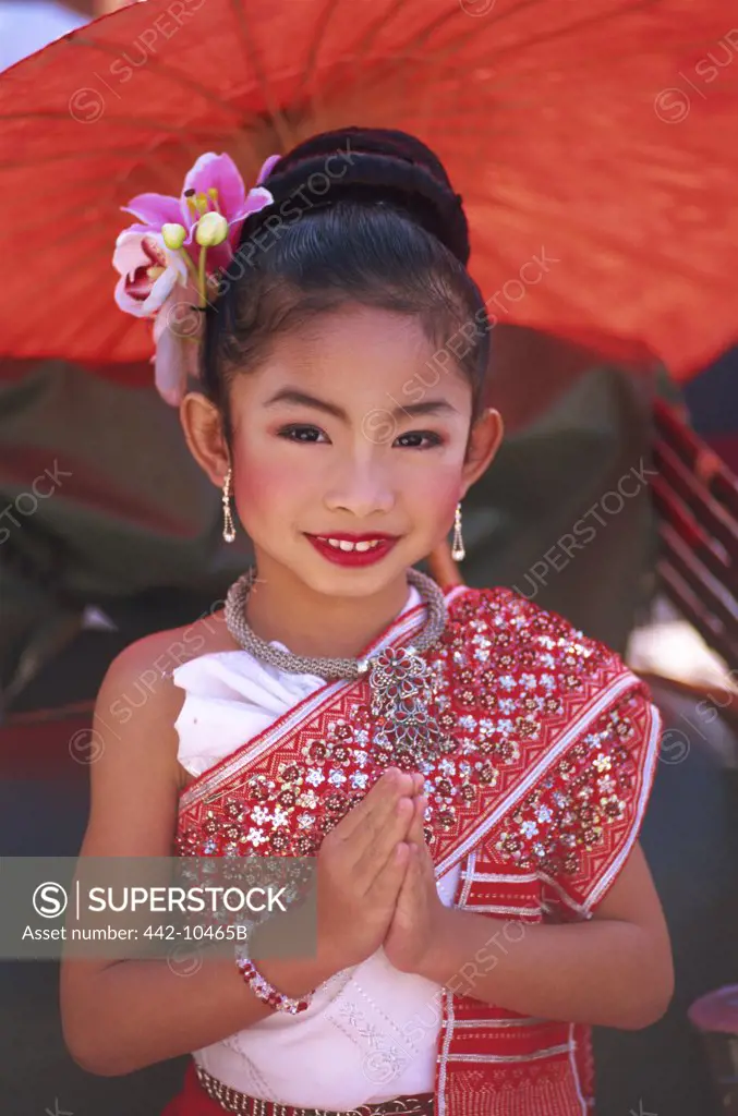 Portrait of a girl in traditional Thai costume with her hands folded at a traditional festival, Chiang Mai Flower Festival, Chiang Mai, Chiang Mai Province, Thailand