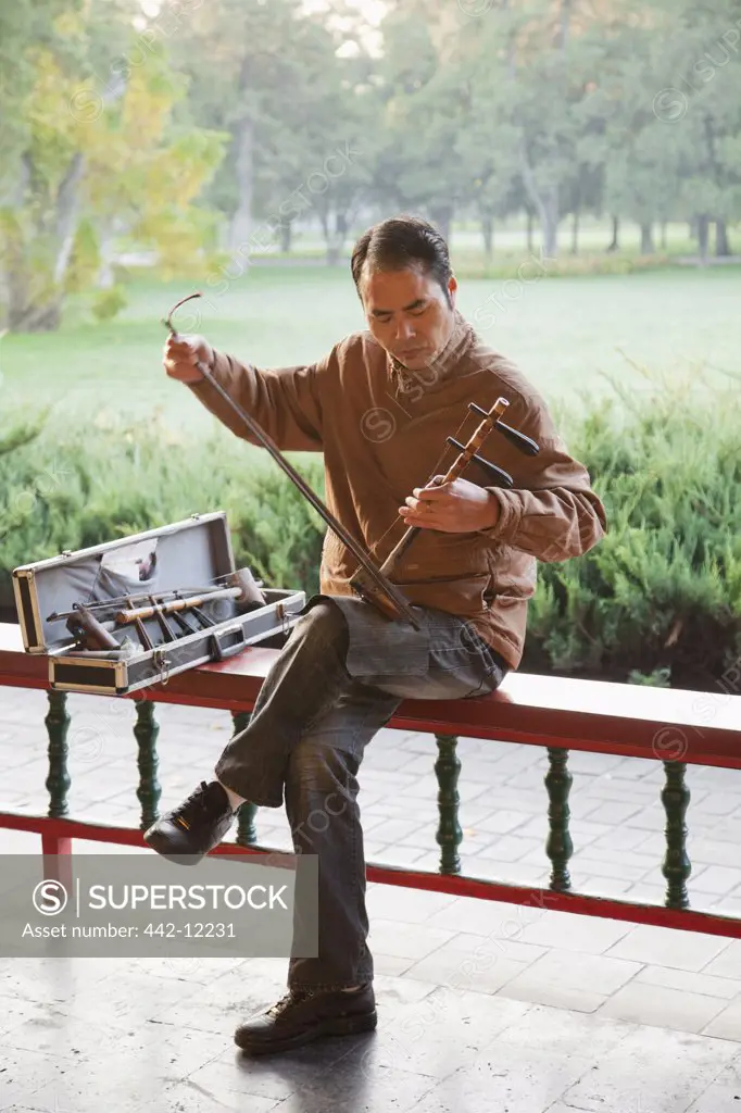 Man playing Erhu the traditional Chinese stringed instrument, Temple Of Heaven, Beijing, China