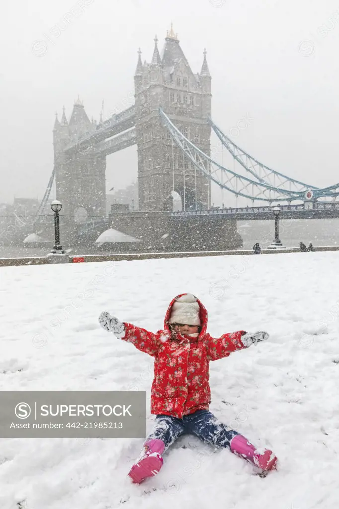 England, London, Southwark, Child Playing in the Snow with Tower Bridge in the Background