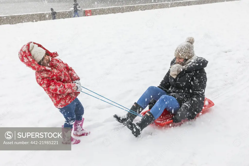 England, London, Southwark, Potters Field, Mother and Child Playing in the Snow 