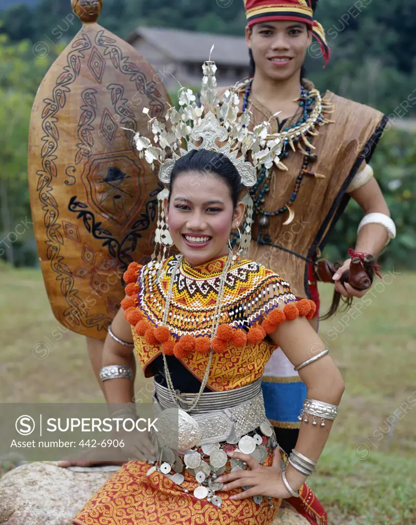 Portrait of an Iban woman and man dressed in traditional costumes, Sarawak Cultural Village, Sarawak, Malaysia