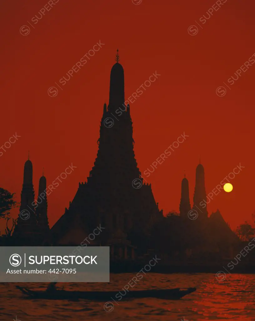 Sunset over a temple, Wat Arun, Chao Phraya River, Bangkok, Thailand