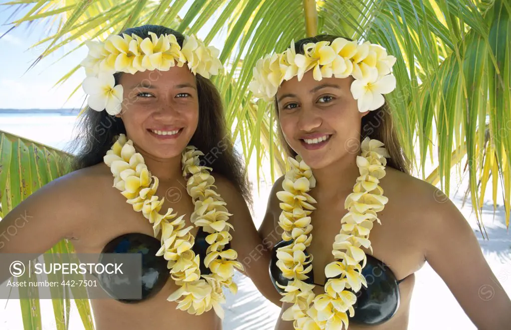 Portrait of two teenage girls dressed in traditional costumes with leis, Aitutaki Island, Cook Islands, Polynesia