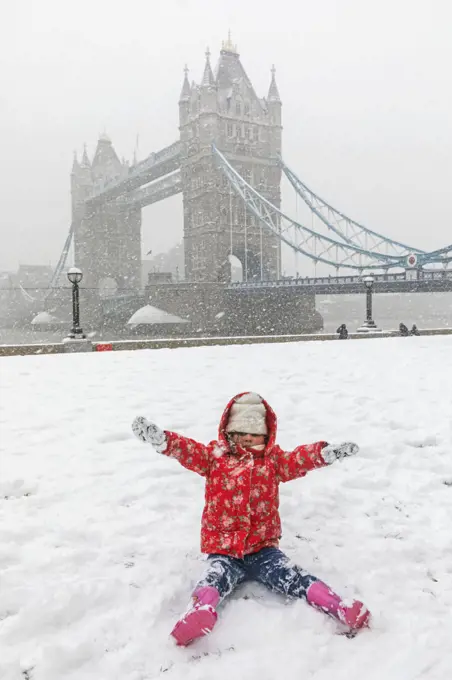 England, London, Southwark, Child Playing in the Snow with Tower Bridge in the Background