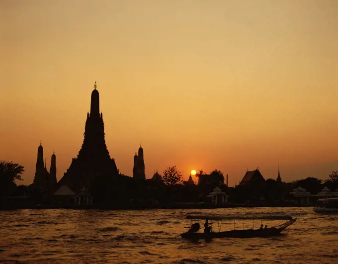 Sunset over a temple, Wat Arun, Chao Phraya River, Bangkok, Thailand