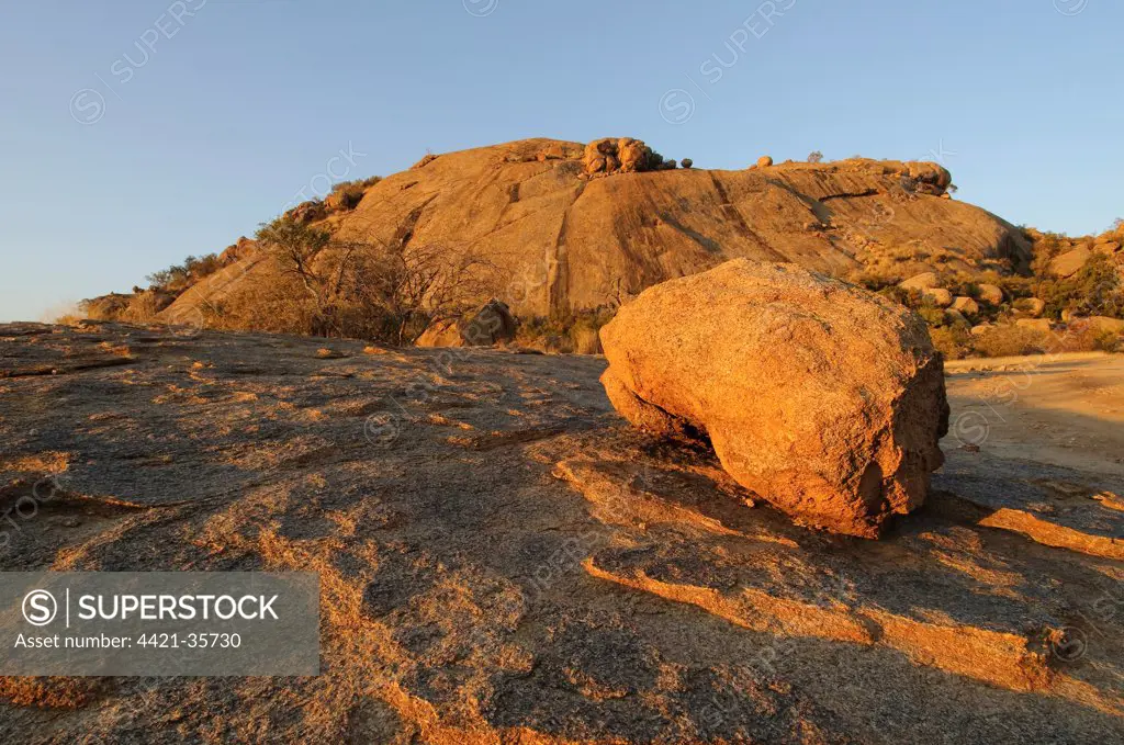 Weathered granite boulders, scattered on granite outcrop in desert, in evening sunshine, Erongo, Namibia