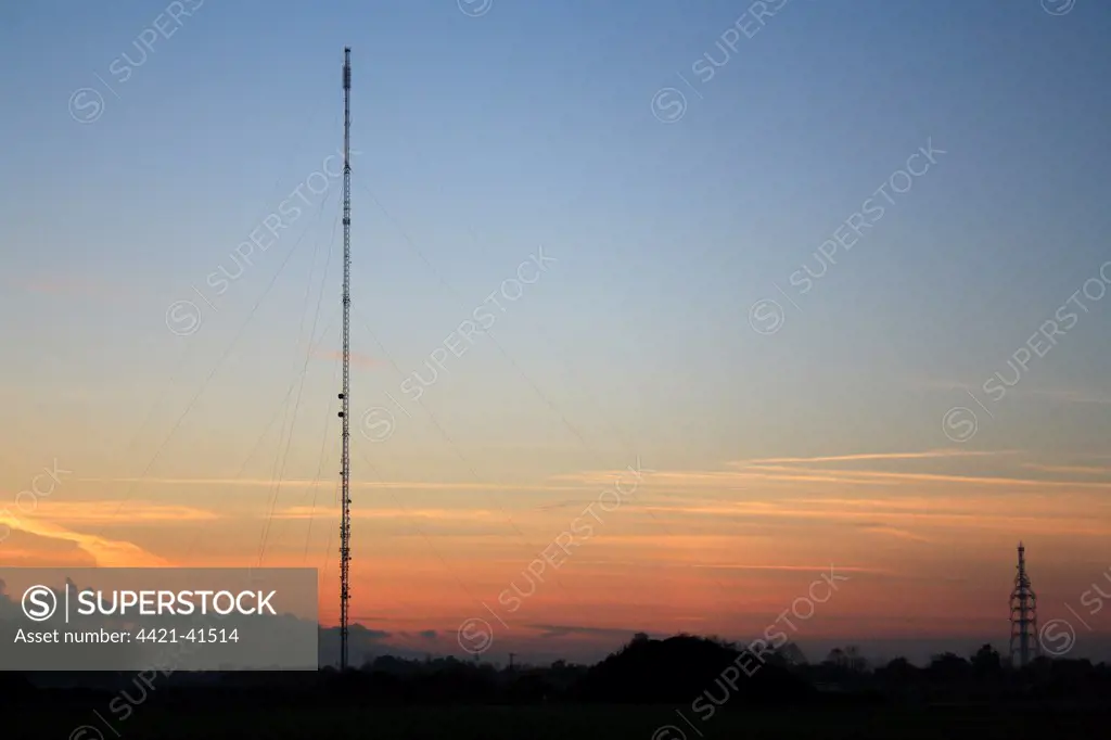 Broadcasting and telecommunication facility with guyed steel lattice mast silhouetted at sunset, Mendlesham Mast, Mendlesham Transmitting Station, Mendlesham, Suffolk, England, november