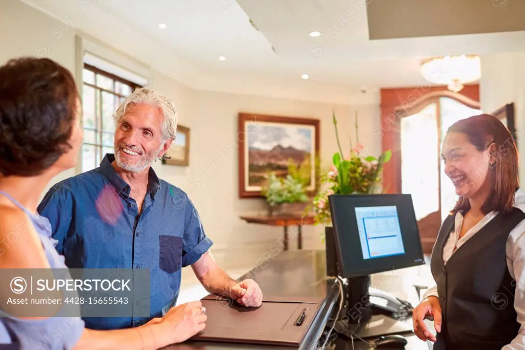 Mature couple checking in at hotel reception