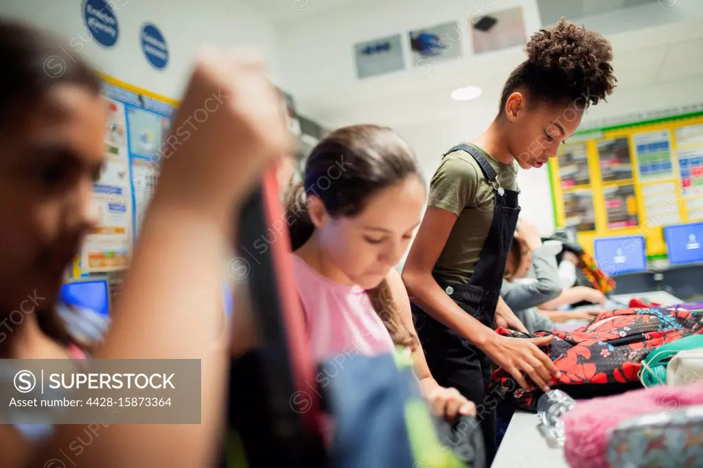 Junior high school girl students with backpacks in classroom