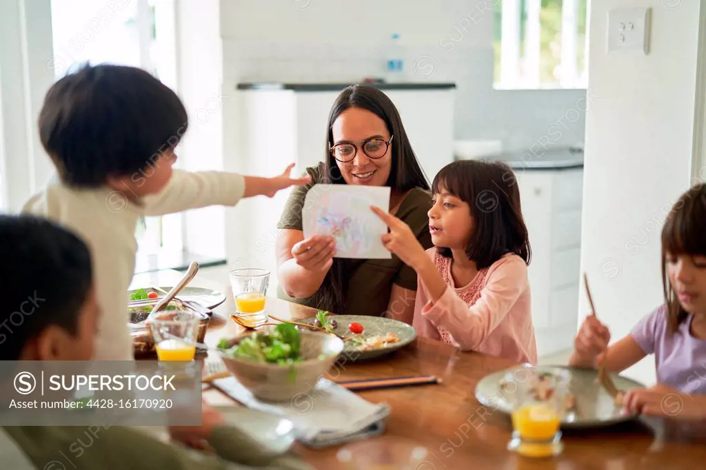 Mother and kids eating lunch at dining table