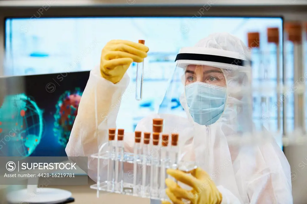 Female scientist in clean suit researching coronavirus vaccine