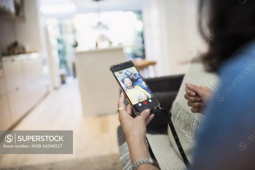 Woman video chatting with parents on smart phone screen