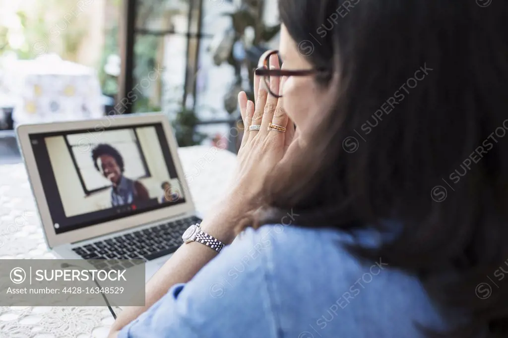 Woman video conferencing with colleagues at laptop screen