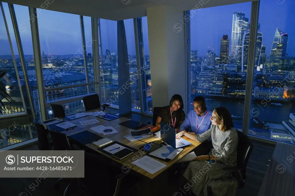 Business people working late in highrise office, London, UK