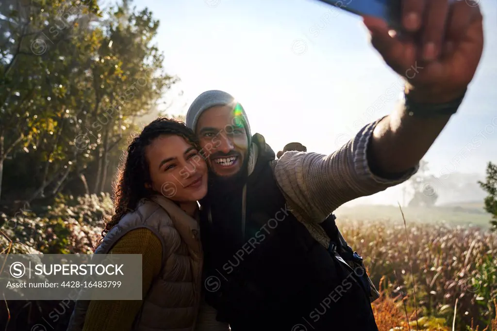 Happy young couple taking selfie on hike