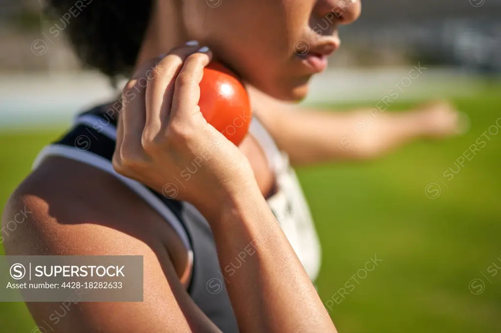 Close up female track and field athlete preparing to throw shot put