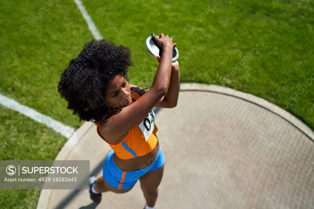 Female track and field athlete throwing discus