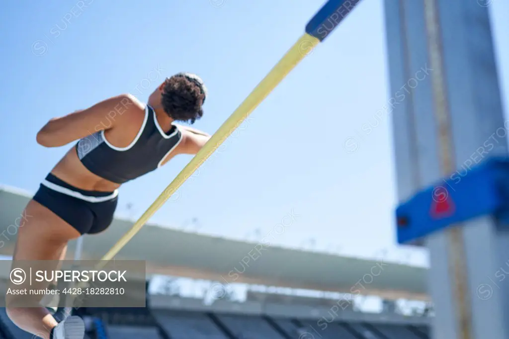 Female track and field athlete high jumping