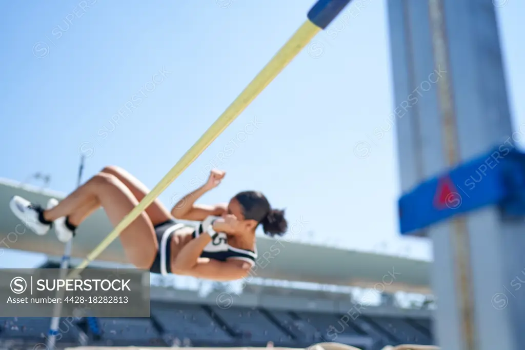 Female track and field athlete high jumping