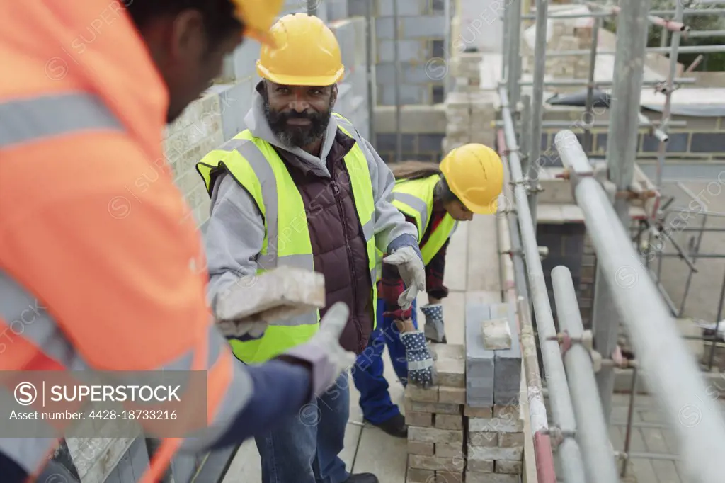 Construction workers laying brick at construction site