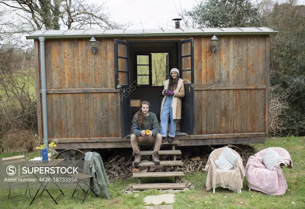 Portrait young couple in tiny cabin rental doorway