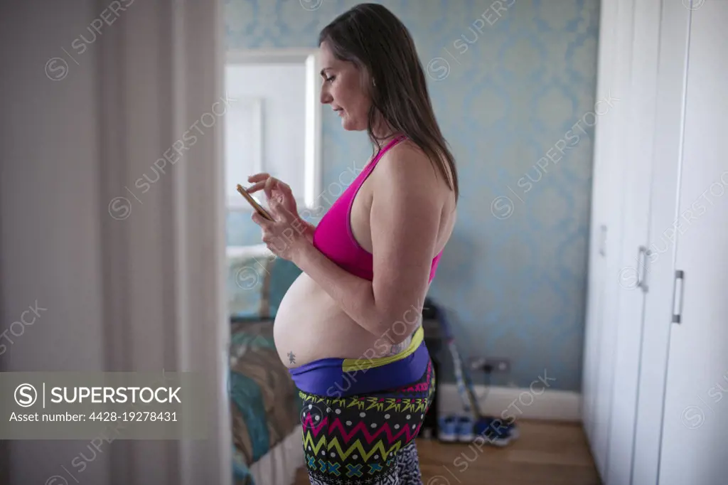 Pregnant woman in sports bra - SuperStock