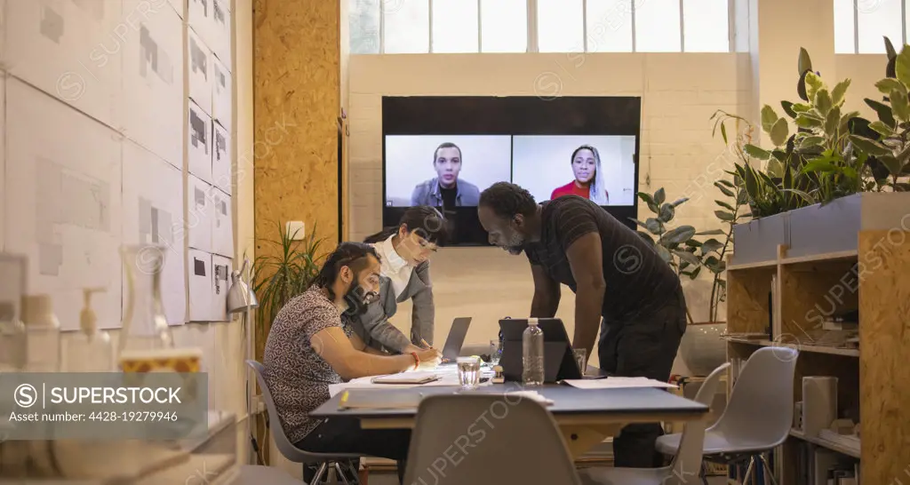 Architects video conferencing in office meeting