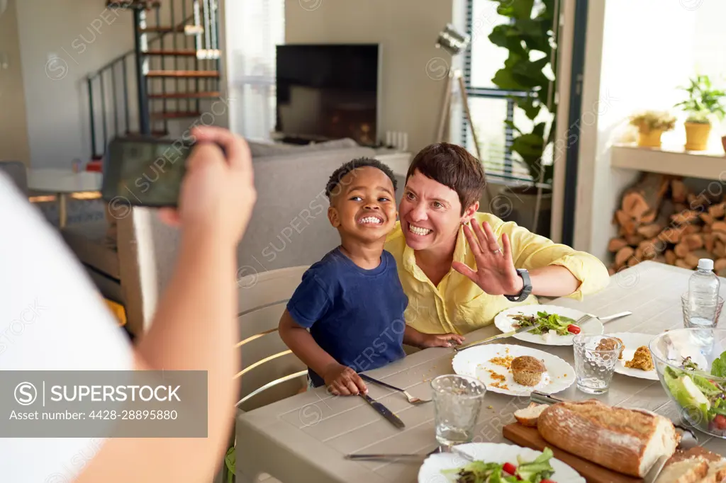 Happy mother and son posing for photo at dinner table