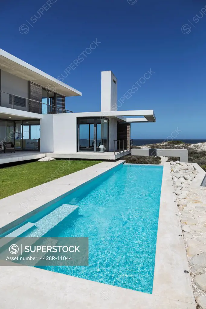 Lap pool and lawn outside modern house