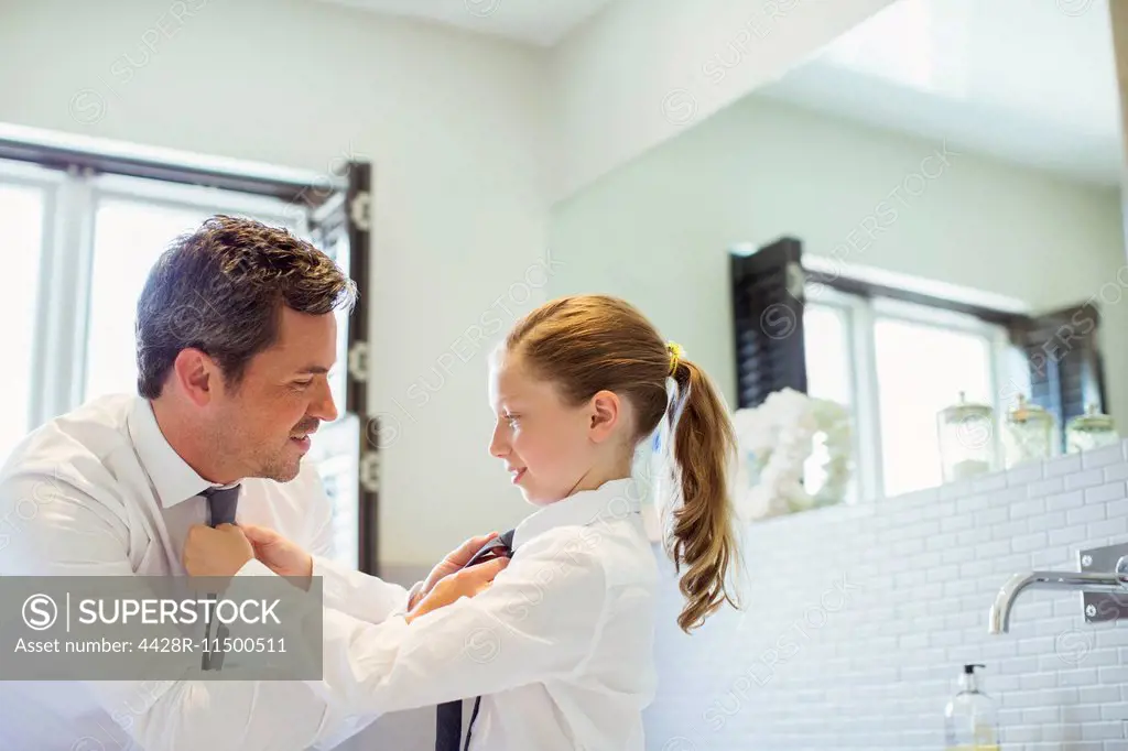 Father and daughter tying each other's ties