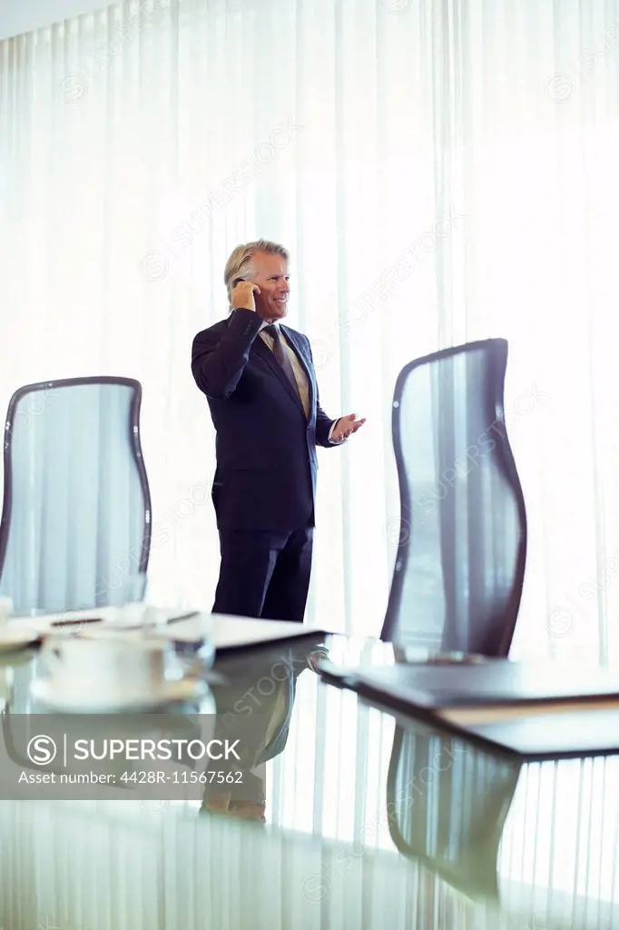 Man standing in conference room talking on his mobile phone