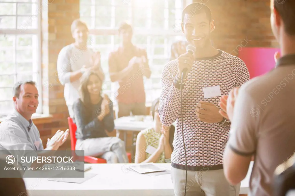 Audience clapping for smiling speaker