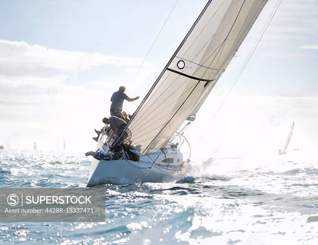 Sailboat heeling on sunny ocean