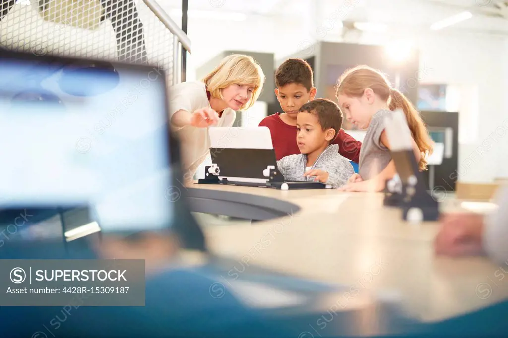 Teacher and students using laptop