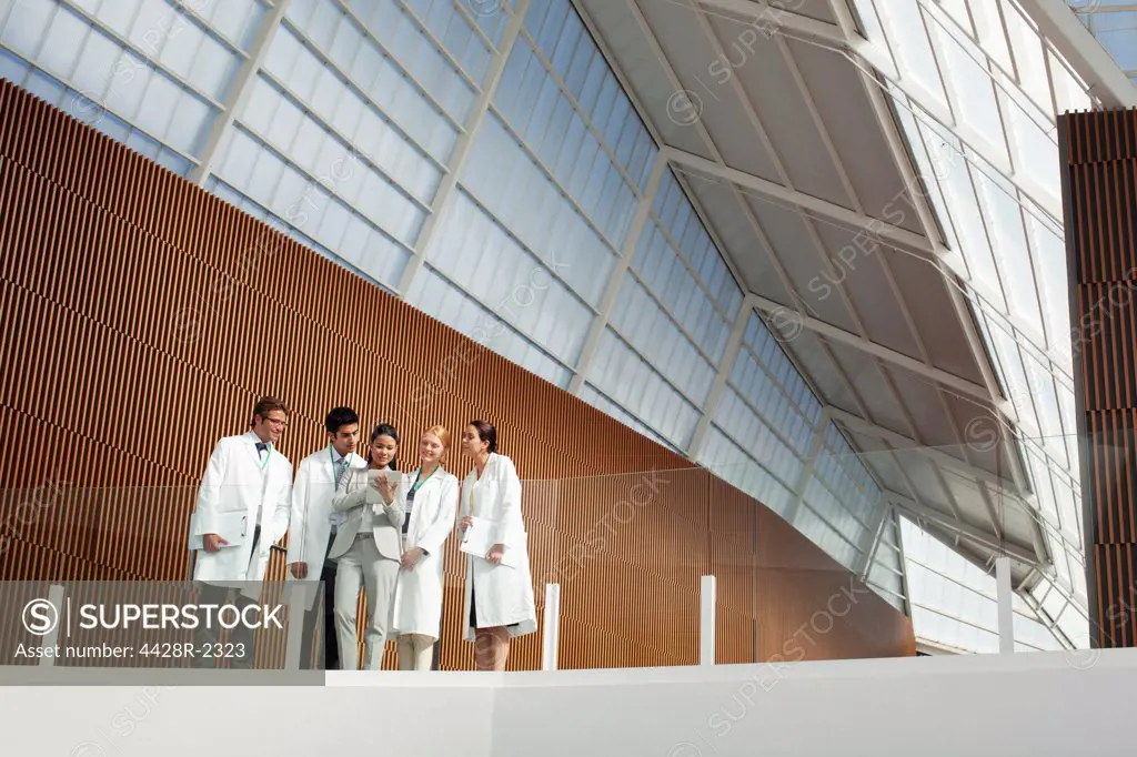 Spain, Doctors and businesswoman using digital tablet on modern balcony