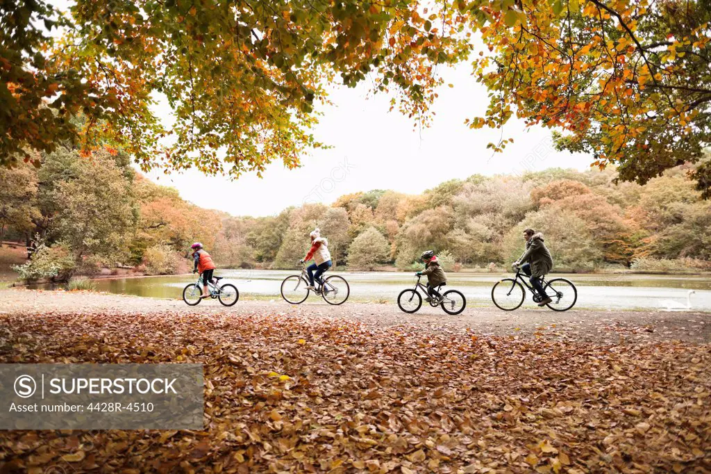 Family riding bicycles in park,London, UK