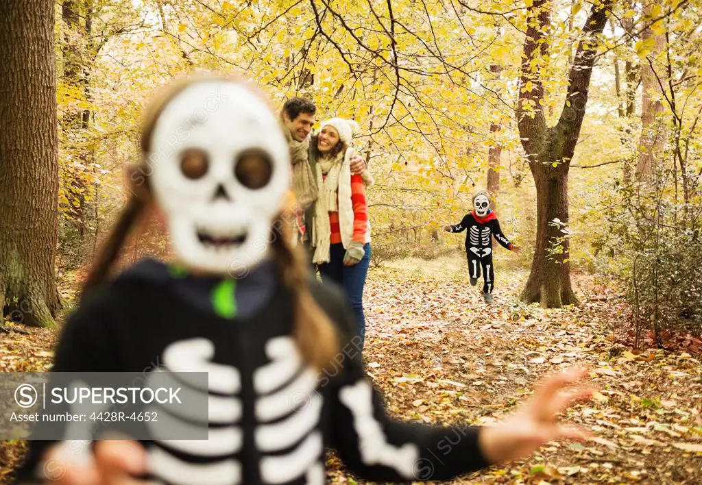 Children in skeleton costumes playing in park,London, UK