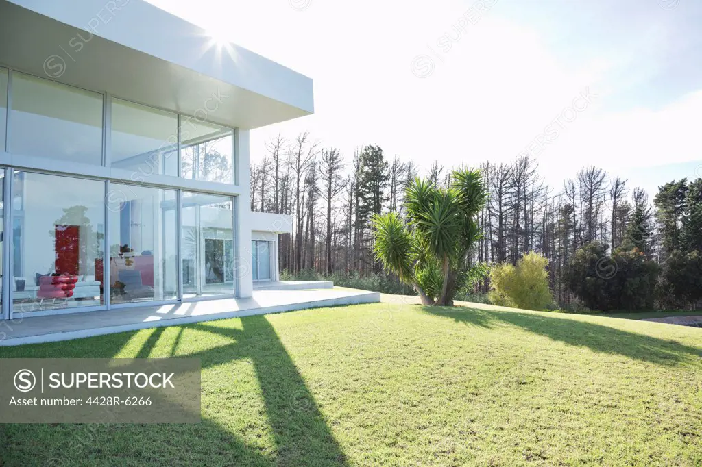 Modern house casting shadows on manicured lawn