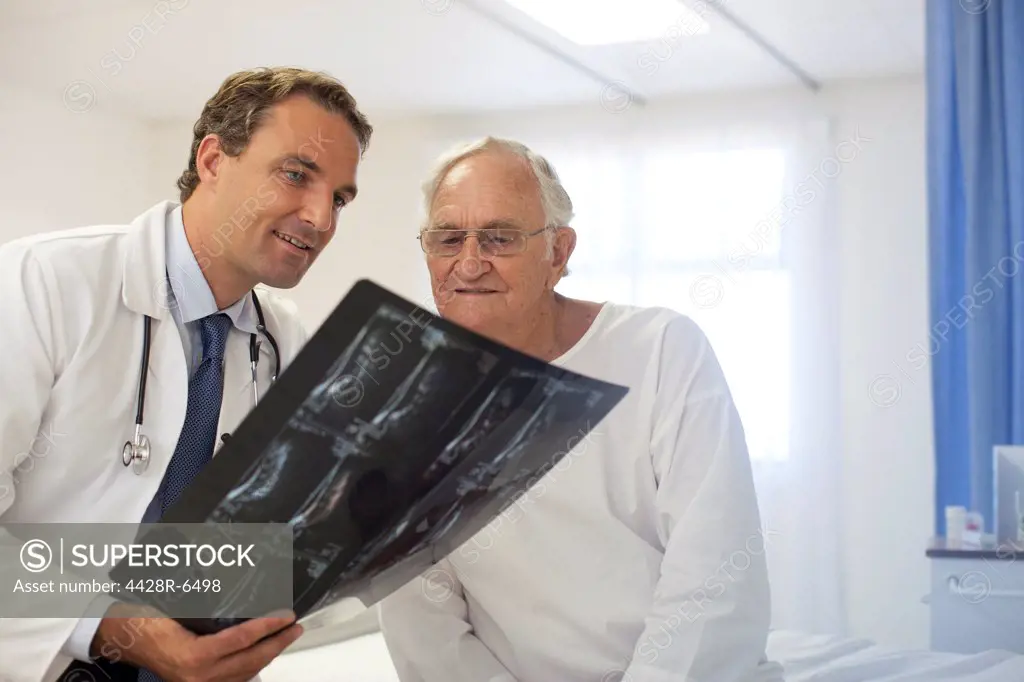 Doctor and patient examining x-rays in hospital room