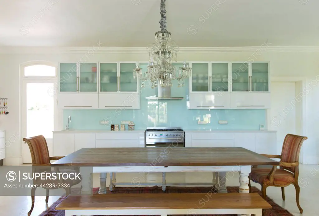 Chandelier over wooden table in kitchen