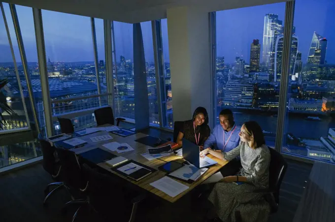 Business people working late in highrise office, London, UK