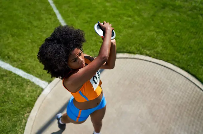 Female track and field athlete throwing discus